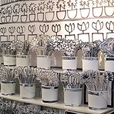 many flower pots are lined up on a shelf