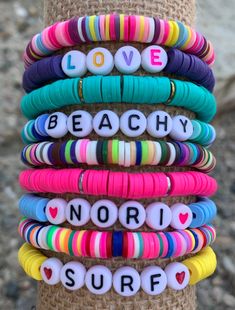 a stack of bracelets that say love beachy, north shore and love is in the air