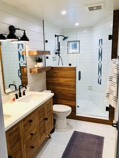 a bathroom with two sinks, a toilet and a shower