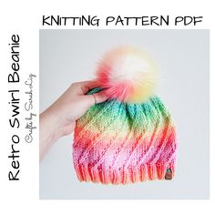 a knitted hat with multicolored yarn and a pom - pom