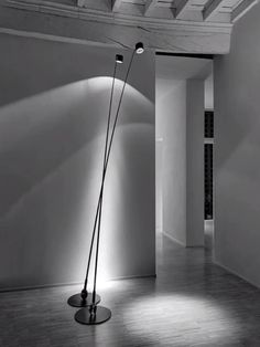 a black and white photo of an empty room with two floor lamps in the corner