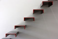 red and black shelves on the side of a white wall