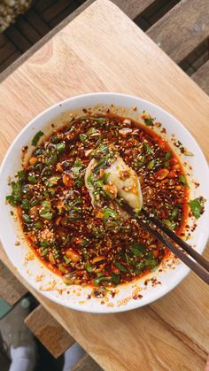 a white bowl filled with food on top of a wooden table