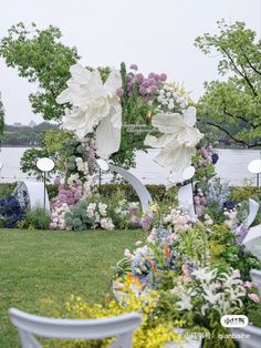 an outdoor garden with flowers and white chairs