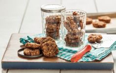 some cookies are sitting on a cutting board next to a glass with something in it