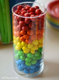 a glass filled with candy sitting on top of a table