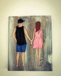 two people holding hands while standing next to each other in front of a wooden wall