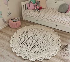 a crochet doily is laying on the floor next to a small bed