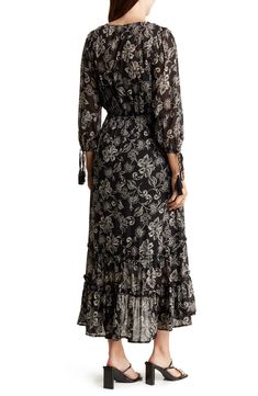 A charming floral print adorns a flowy high-low dress framed by three-quarter sleeves with tassel tie cuffs. 36 1/2" shortest length; 48 1/2" longest length V-neck Three-quarter sleeves Partially lined 100% polyester Dry clean or hand wash, dry flat Imported Model stats: 5'10" height, 32" bust, 25" waist, 36" hip. Model is wearing size Small. Elegant Midi Dress With 3/4 Sleeves For Beach, Flowy Midi Dress With 3/4 Sleeves For Vacation, Bohemian Flowy Midi Dress With 3/4 Sleeves, Elegant Flowy Maxi Dress With 3/4 Sleeves, Flowy Bohemian Midi Dress With 3/4 Sleeves, Bohemian Midi Dress With 3/4 Sleeves And Flowy Fit, Chic Flowy Maxi Dress With 3/4 Sleeves, Floral Print Flowy Dress With 3/4 Sleeves, Elegant Maxi Dress With 3/4 Sleeves For Beach