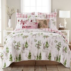 a bed covered in white and green christmas themed comforters with red plaid pillow cases