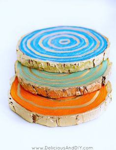 four coasters stacked on top of each other in different colors and sizes, with the tops painted orange, blue, and green