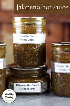 jars of jalapeno hot sauce sitting on a table with the words jalapeno hot sauce in front of them