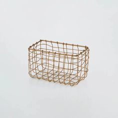 a wire basket on a white surface with no one in the photo to describe it