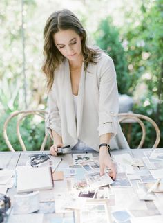 a woman sitting at a table with pictures on it