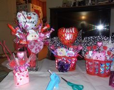 valentine's day gifts are sitting on a table with scissors and balloons in them