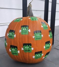 an orange pumpkin decorated with cartoon faces on it's face and eyes, sitting in front of a house