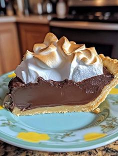 a piece of chocolate pie on a blue and yellow plate with a flowered design