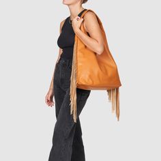 The Texas Star Bag by Urban Originals is a soft and triangular slouch bag designed with a clean-cut indent and a smooth vegan leather finish. This fringed tote has plenty of card slots with a one zipper pocket and two slip pockets for essentials and a fully detachable keyring. Brown Tassel Hobo Tote Bag, Brown Tassel Tote Shoulder Bag, Brown Fringe Tote Shoulder Bag, Brown Leather Fringe Shoulder Bag, Daily-use Brown Bag With Fringe, Slouch Bags, Texas Star, Rebecca Minkoff Hobo, Zipper Pocket