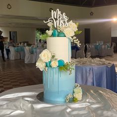 a blue and white wedding cake sitting on top of a table