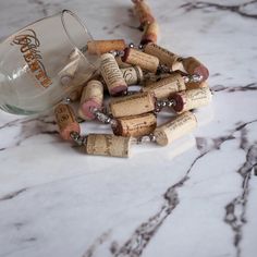 several wine corks and a glass on a marble counter top with the corks still attached