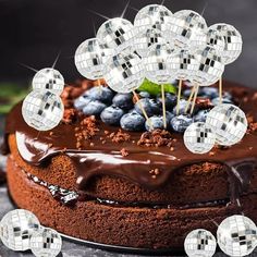 a chocolate cake topped with blueberries and disco balls