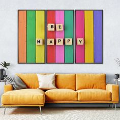 a living room with a couch and two colorful blocks on the wall that spell out be happy