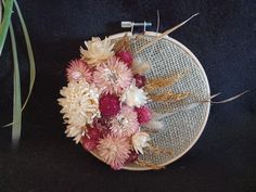 a close up of a flower arrangement in a embroidery hoop on a black table cloth