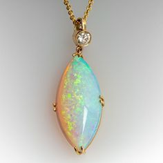 an opal and diamond pendant on a chain