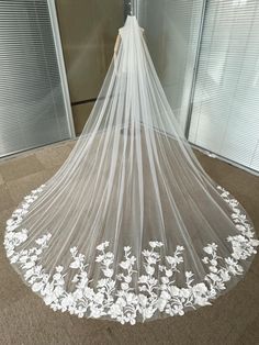 a wedding veil with white flowers on it