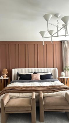 a large bed sitting in the middle of a bedroom next to two tables and lamps