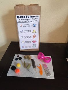 a paper bag sitting on top of a table next to scissors and other items that are in front of it