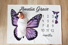 a baby wrapped in a blanket with a purple butterfly on it and the birth date