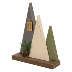 three triangular wooden ornaments with pine cones on each one and a tag hanging from the top