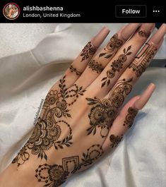 a woman's hand with henna tattoos on it