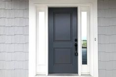 a gray front door with white trim on a house