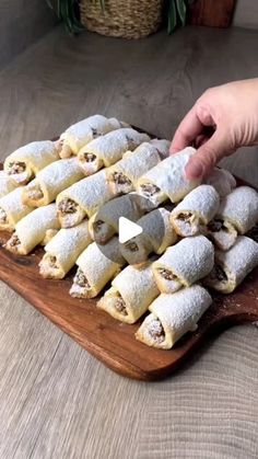 a wooden cutting board topped with pastries on top of a table