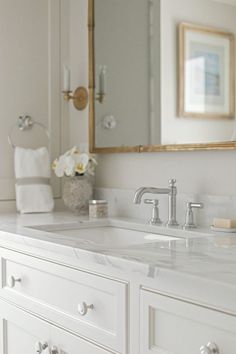 a white bathroom with two sinks and a large mirror