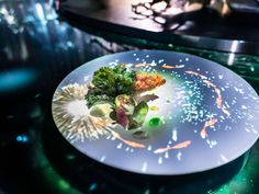 a white plate topped with broccoli on top of a table