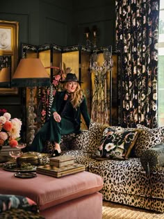 a woman sitting on top of a leopard print couch