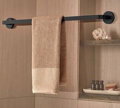 a towel hanging on the side of a bathroom wall next to a shelf with towels