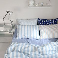 a bed with blue and white striped pillows