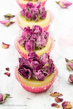 three cupcakes with purple flowers on them