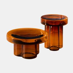 two brown glass vases sitting next to each other on top of a white surface