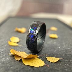 a black ring with blue and yellow leaves on the ground