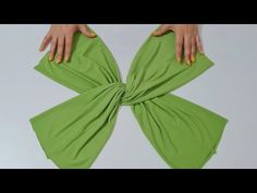 a woman's hands on top of a green cloth with a knot around it