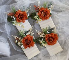 three wedding boutions with orange roses and baby's breath