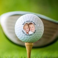 a golf ball with a photo on it and a wooden tee in the foreground