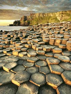 the giant rock formations are made up of hexagonal rocks, with water in the background