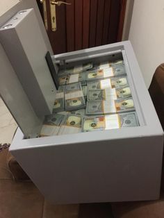 a bunch of money is sitting in a filing cabinet with the door open to reveal it's contents