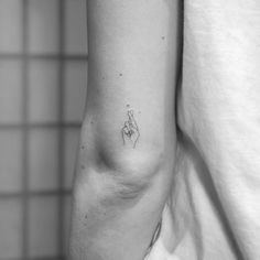 a woman's arm with a small tattoo on the left side of her arm